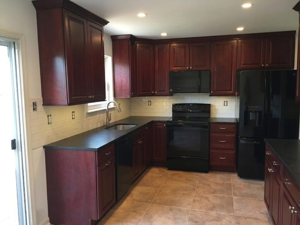 image showing kitchen with cherry wood cabinets, black countertops, tilebacksplash and tile floor